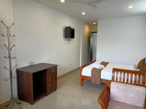 1 dormitorio con 1 cama y TV en la pared en Silver Munnar, en Munnar