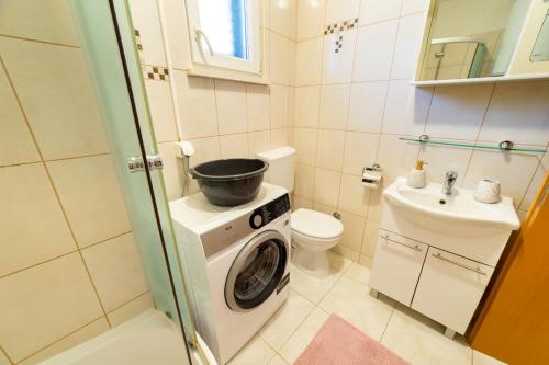 baño pequeño con lavadora y lavamanos en Apartment Happy in Split center 10 min walk from Bačvice beach, en Split