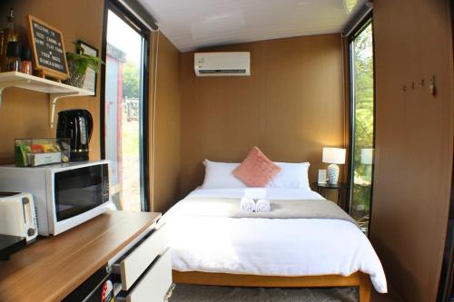 - une petite chambre avec un lit et une télévision dans l'établissement Dairy Flat Farm Cabin 2, à Waitoki