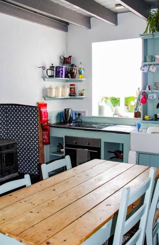 a kitchen with a wooden table and some chairs at Boss’s farmhouse in Valentia Island