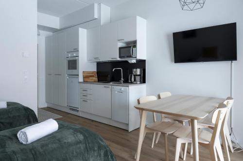a living room with a table and a kitchen at Studio Brita in Helsinki