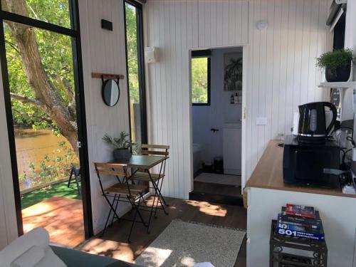 Habitación con cocina, mesa y puerta en The Hide Away Cabin, en Redwoods Valley