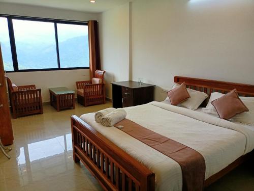 um quarto com uma cama grande e uma janela grande em Silver Munnar em Munnar