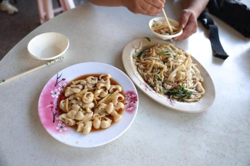 una mesa con dos platos de comida y un plato de pasta en The Dawn 2, en Kaohsiung