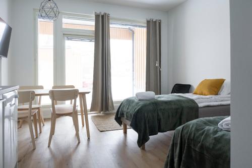 um quarto com uma cama, uma mesa e cadeiras em Studio Brita em Helsínquia