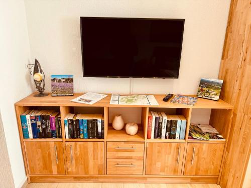 un centro de entretenimiento de madera con TV de pantalla plana en Ferienwohnung Haus Feig, en Geyer