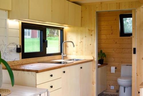 a kitchen with a sink and a toilet at Bostebacken Gard Tiny House in Eckerud