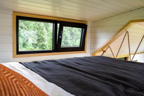 a bedroom with a bed and a window at Bostebacken Gard Tiny House in Eckerud