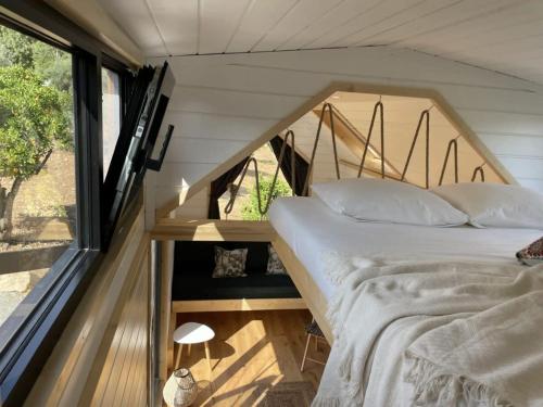 een bed in een tiny house met een raam bij La Vista Huma in Alora