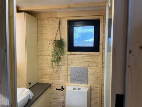 Elle comprend une petite salle de bains pourvue de toilettes et d'une fenêtre. dans l'établissement Lisi Grun Tiny House, à Sattledt