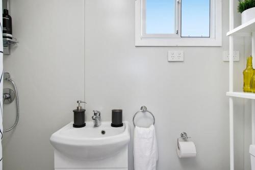 a white bathroom with a sink and a window at Malniri Park in Wilberforce