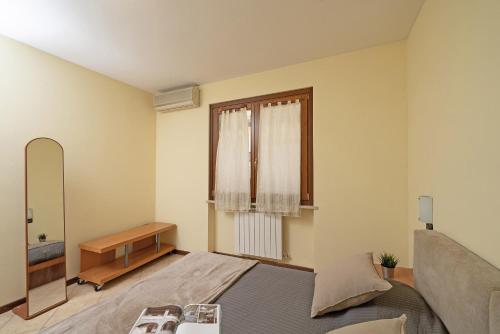 een slaapkamer met een bed, een spiegel en een raam bij Borgo delle Colline 19 by Wonderful Italy in Manerba del Garda