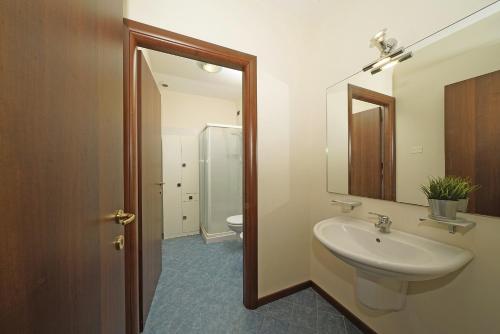 een badkamer met een wastafel, een spiegel en een toilet bij Borgo delle Colline 19 by Wonderful Italy in Manerba del Garda