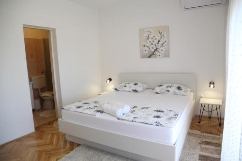 een witte slaapkamer met een bed in een kamer bij Rooms Kresan in Zadar