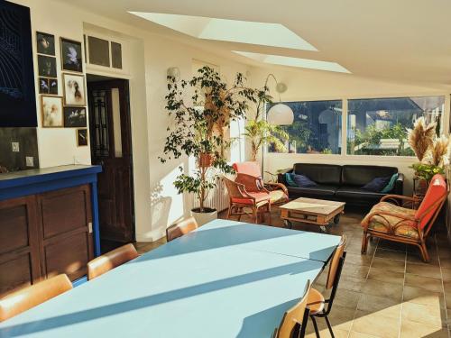 een woonkamer met een blauwe tafel en stoelen bij La Maison du Cosquer in Camaret-sur-Mer