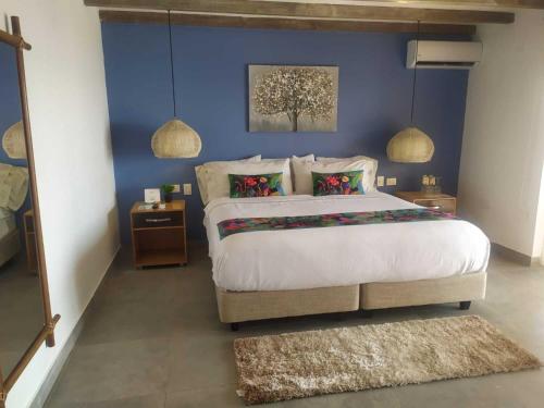 a bedroom with a large bed with a blue wall at Solare SAI Ecohotel in San Andrés