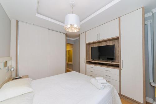 1 dormitorio con 2 camas y TV de pantalla plana en Amplo Apto 2sui+1Q Vista Mar 50m da Praia, en Balneário Camboriú