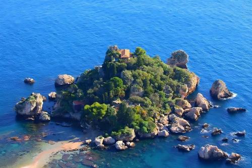 an island in the ocean with a house on it at Casa Vacanze Etna Sunset in Giarre
