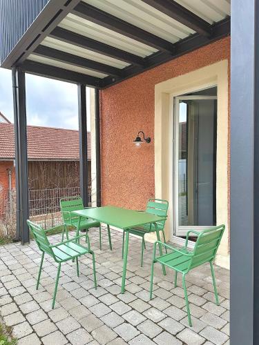 a green table and chairs on a patio at betterplaces: Boutique Apartments - Frontenhausen in Dingolfing