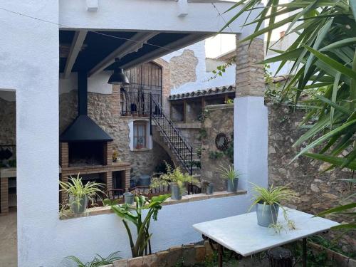 un patio al aire libre con una mesa y macetas en Ca la Trini - turisme rural, en Torrelles de Foix