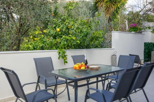 a table with chairs and a bowl of fruit on a patio at Over the Messinian Plain in Kalamata