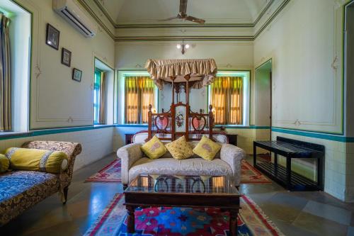 a living room with a couch and a table at Koolwal Kothi Zinc Journey by The Fern, Nawalgarh, Rajasthan in Nawalgarh