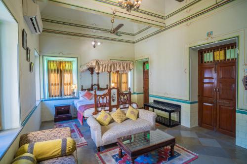a living room with a bed and a couch at Koolwal Kothi Zinc Journey by The Fern, Nawalgarh, Rajasthan in Nawalgarh