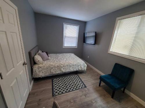 1 dormitorio con 1 cama y 1 silla azul en Spacious Retreat, en Carbondale