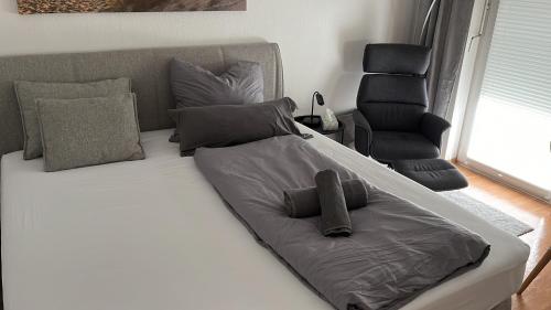 ein Bett mit einem Kissen und einem Stuhl in einem Zimmer in der Unterkunft Apartment 3 ideal für Familien und Geschäftsreisende ABG69 in Gera