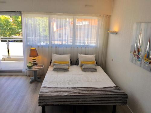 un grand lit dans une chambre avec une fenêtre dans l'établissement APPART 4 PERS. BALCON & PARKING - PLAGE & COMMERCES, à Arcachon