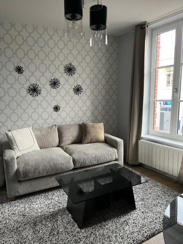 a living room with a couch and a coffee table at Le Balbec in Cabourg