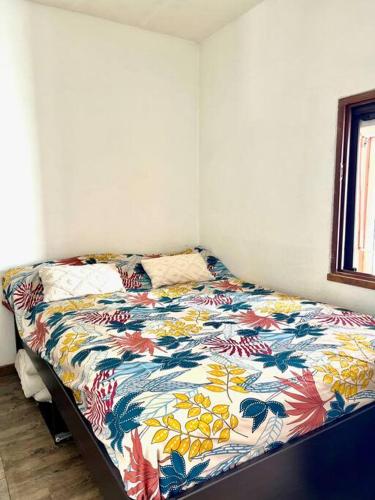 Ce lit se trouve dans un dortoir doté d'une couette colorée. dans l'établissement Miroir de la mer, appartement vue mer pied dans l eau, à Fréjus