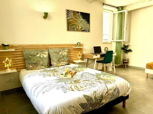 une chambre avec un lit et un bureau avec un ordinateur portable dans l'établissement Évasion Jungle, à Narbonne