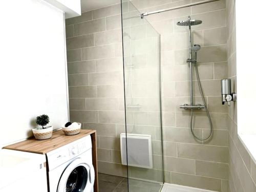une douche dans une salle de bain avec machine à laver dans l'établissement Évasion Jungle, à Narbonne
