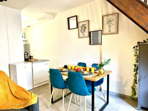 une salle à manger avec une table et des chaises bleues dans l'établissement Évasion Jungle, à Narbonne