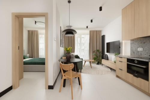 JTB Apartamenty Centrum في شتتين: مطبخ وغرفة معيشة مع طاولة وغرفة نوم