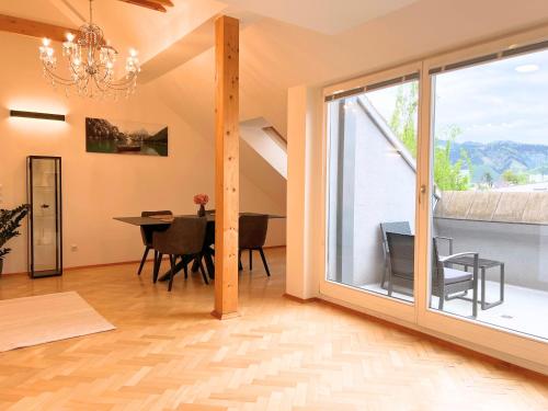 a dining room with a large window and a dining table at Leoben City Apartments - Premium Apartments 24 7 in Leoben