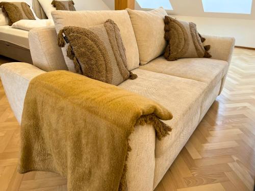 a couch with a blanket on it in a living room at Leoben City Apartments - Premium Apartments 24 7 in Leoben