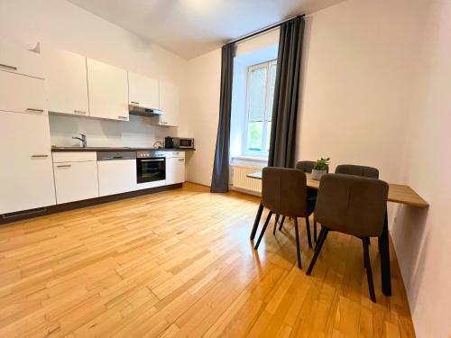 a kitchen and dining room with a table and chairs at Leoben City Apartments - Premium Apartments 24 7 in Leoben