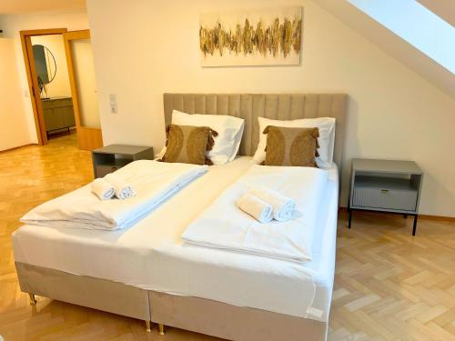 a bedroom with a large bed with towels on it at Leoben City Apartments - Premium Apartments 24 7 in Leoben