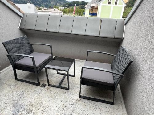 two chairs and a table on a balcony at Leoben City Apartments - Premium Apartments 24 7 in Leoben