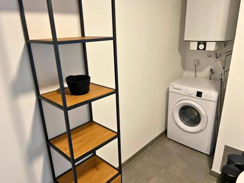 a black shelf in a bathroom with a washing machine at Leoben City Apartments - Premium Apartments 24 7 in Leoben