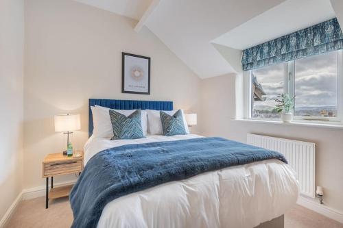 a bedroom with a bed with a blue blanket and a window at Dwarf Hall - central Ambleside in Ambleside