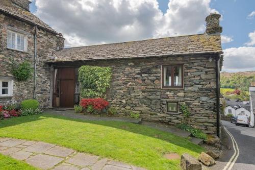 a stone house with a grass yard in front of it at Dwarf Hall - central Ambleside in Ambleside