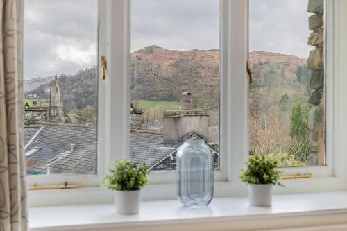 a window with two potted plants and a glass vase at Dwarf Hall - central Ambleside in Ambleside