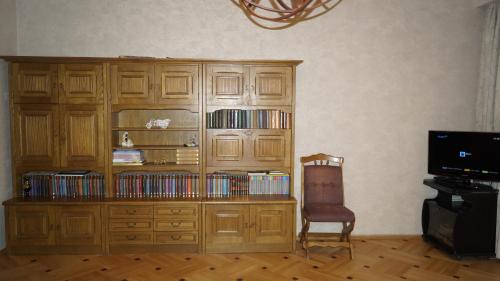 a wooden entertainment center with a book shelf with dvds at Nino's Guest House in Tbilisi City