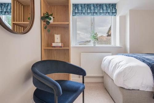 a bedroom with a blue chair next to a bed at Dwarf Hall - central Ambleside in Ambleside