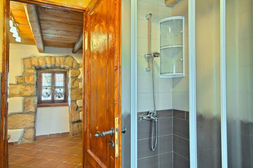 ein Bad mit einer Dusche und einer Glastür in der Unterkunft Beautiful stone Villa with private pool near Rabac in Barbići