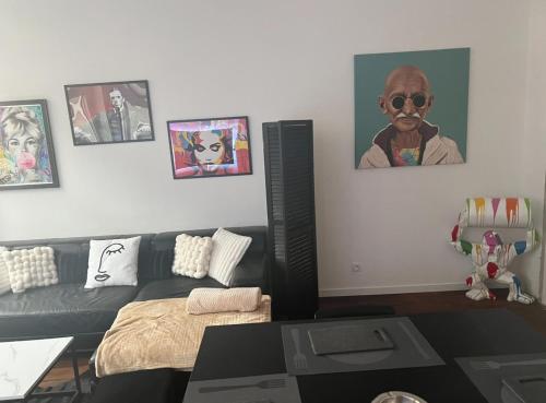 a living room with a couch and pictures on the wall at Romeo et juliette in Spa