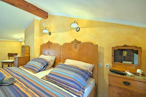 Schlafzimmer mit einem großen Bett mit einem Kopfteil aus Holz in der Unterkunft Beautiful stone Villa with private pool near Rabac in Barbići